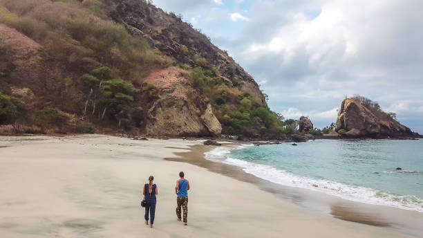 istock Koka Beach - A couple walking on an idyllic beach, surrounded by hills 1200570865