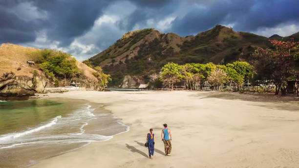 istock Koka Beach - A couple walking on an idyllic beach, surrounded by hills 1200570892