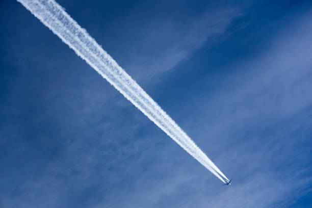 istock Airplane Leaving Contrail against dark Blue sky 1200571912