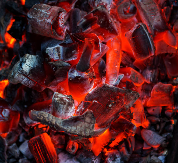 istock Burning coal. Glowing embers smoldering. Fire place with glowing coal. 1200572083