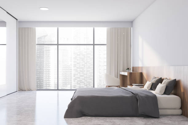 istock Side view of white master bedroom with armchair 1200573991