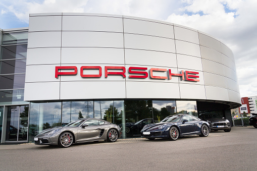 Prague, Czech Republic - September 22, 2018: Porsche logo on car in front of dealership building on September 22, 2018 in Prague, Czech Republic.