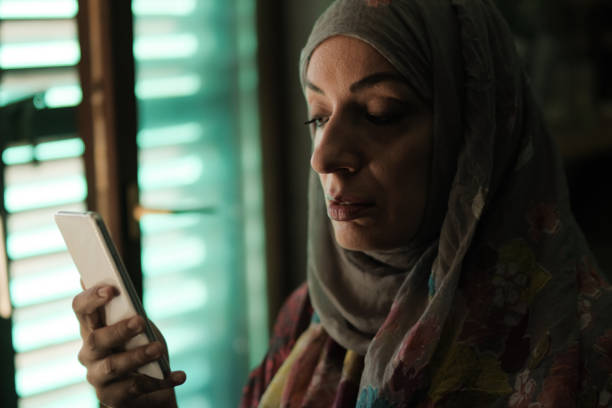 istock Muslim woman using phone in the dark room 1200577914