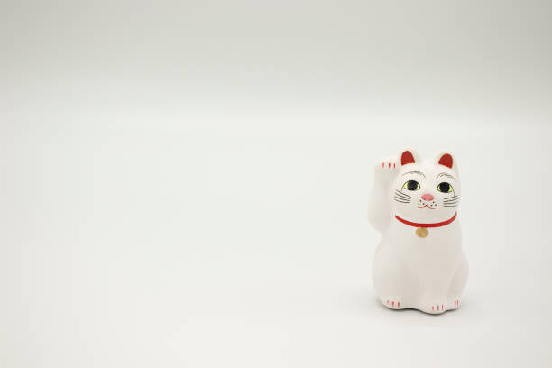 Traditional Maneki Neko Japanese lucky cat in white chalk with raised paw.
