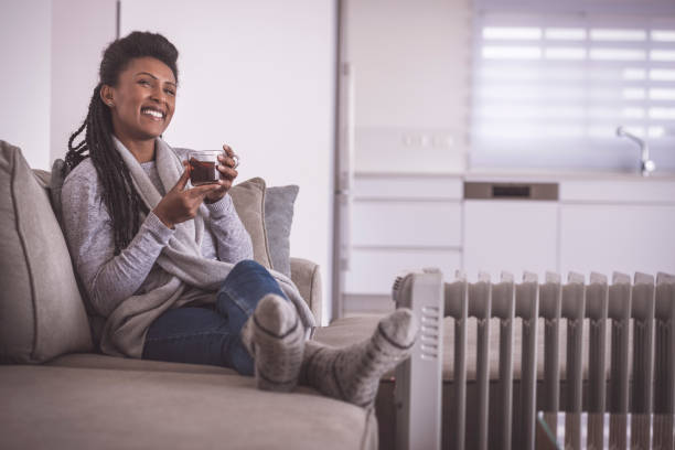 뜨거운 차를 마시는 행복한 여자, 집에서 발을 가열. - knitting residential structure glasses hot drink 뉴스 사진 이미지