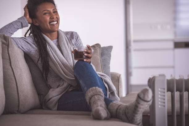 istock Dreaming woman drinking hot tea, heating feet at home. 1200584084