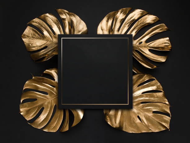 istock Golden monstera leaves on black background 1200585691