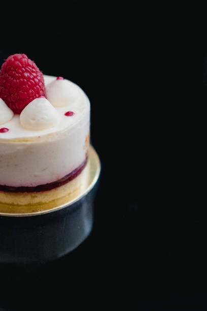istock Luxury white cheesecake mousse cake decorated with fresh raspberries on a dark background. Flat lay. Close-up. Copy space 1200588800