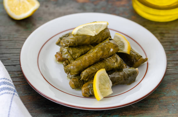 Traditional Turkish Dolma, Sarma or Dolmades,  Eating Traditional Mediterranean Dish Dolmadakia or Stuffed Grapes Leaves on Rustic Background