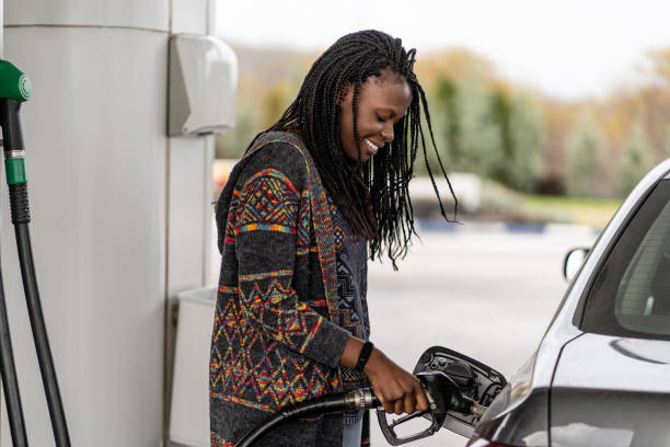 mulher no carro de reabastecimento do posto de gasolina - refueling - fotografias e filmes do acervo