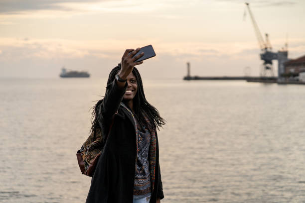 istock Young female taking a selfie in harbour 1200593161