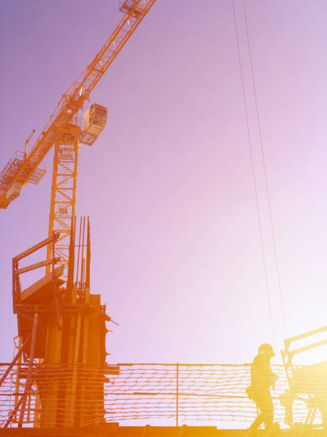 istock Industrial construction cranes and building silhouette at sunrise 1200593959