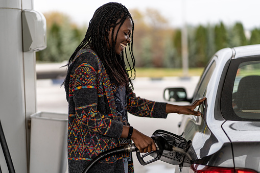 Woman at the gas station refueling car
