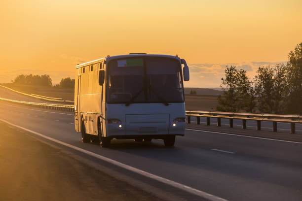 istock bus carries passengers on a suburban highway 1200597370
