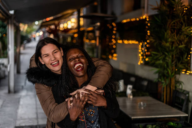 istock Two happy female friends walking on sidewalk 1200597524