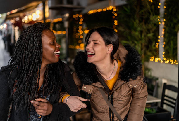 istock Two happy female friends walking on sidewalk 1200599954