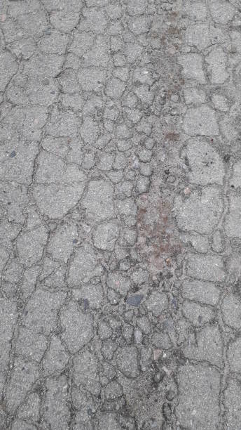 istock Cracked gray old asphalt top the  view 1200600112