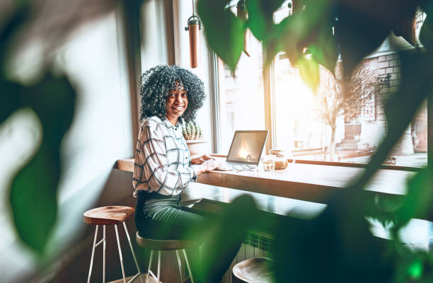 istock It is wonderful when the work is fun. A young african american is working or studying in a beautiful workplace in a cafe. Blurred greens on the sides. 1200602963