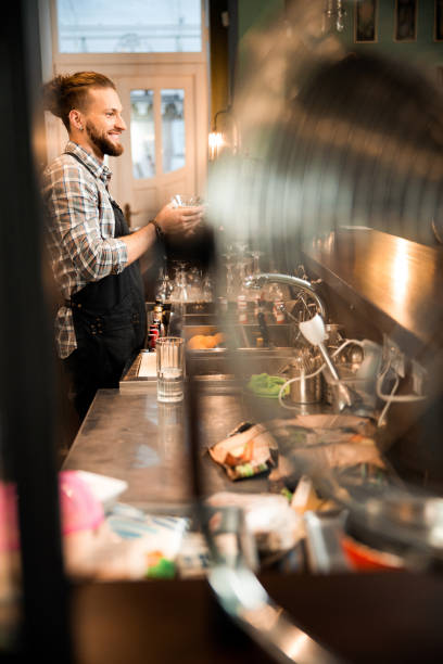 istock Smiling barman is working at the bar 1200606603