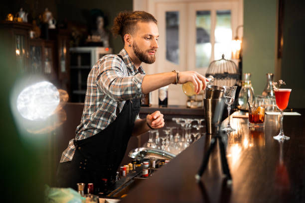 istock Young barman is standing at bar counter 1200606737