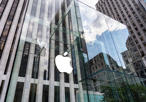 New York, United States - May 19, 2016: Glass building of the Apple Store with huge Apple Logo at 5th Avenue near Central Park. The store is designed as the exterior glass box above the underground display room