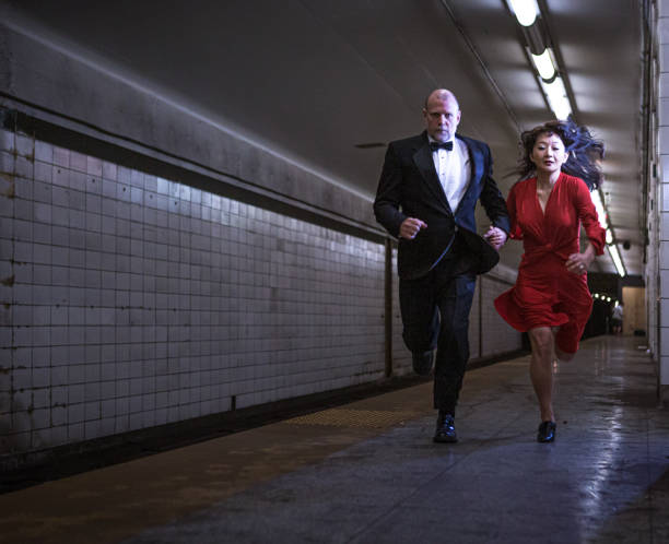 istock Elegant couple running on subway station 1200608700