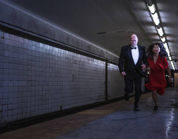 istock Elegant couple running on subway station 1200608819