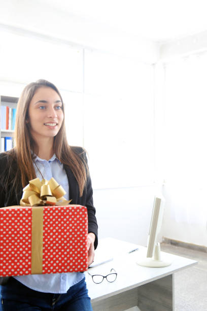 istock Young businesswoman holding a gift 1200609912