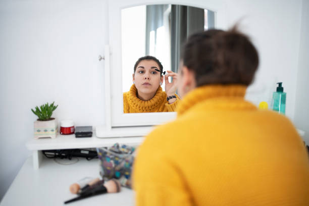 istock Woman applying mascara in mirror 1200610101