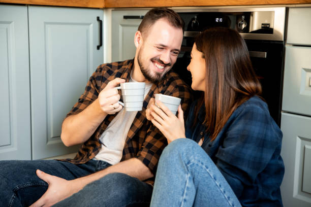 istock Happy couple sit on the floor with a cups 1200610752