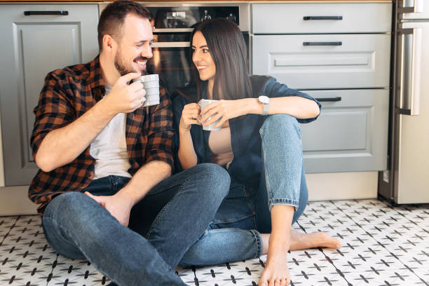 istock Happy couple sit on the floor with a cups 1200610754