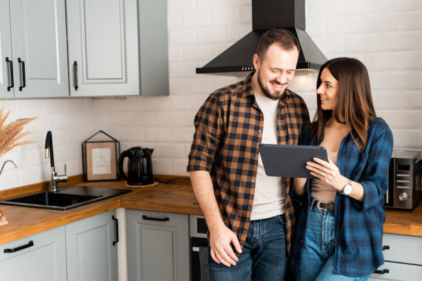istock Girl with a tablet and a guy in the kitchen 1200610770