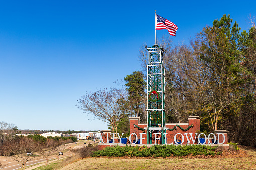 Flowood, MS / USA - December 30, 2019: City of Flowood welcome sign with American Flag waving in the wind, and some holiday decorations