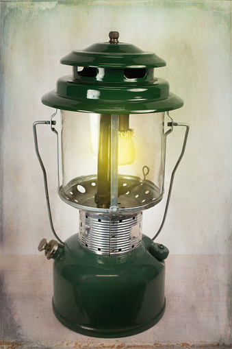 A decorative black hanging gas lantern with flame burning.