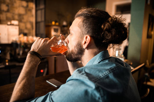 istock Bearded man sitting at bar counter and drinking 1200613851