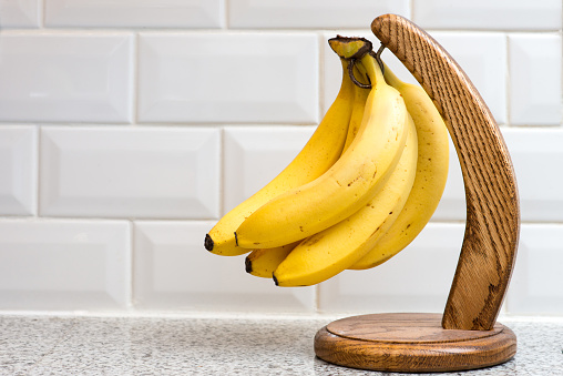 Bananas on banana hanger on kitchen counter