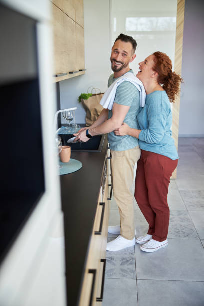 istock Caring couple doing washing-up in kitchen stock photo 1200617331