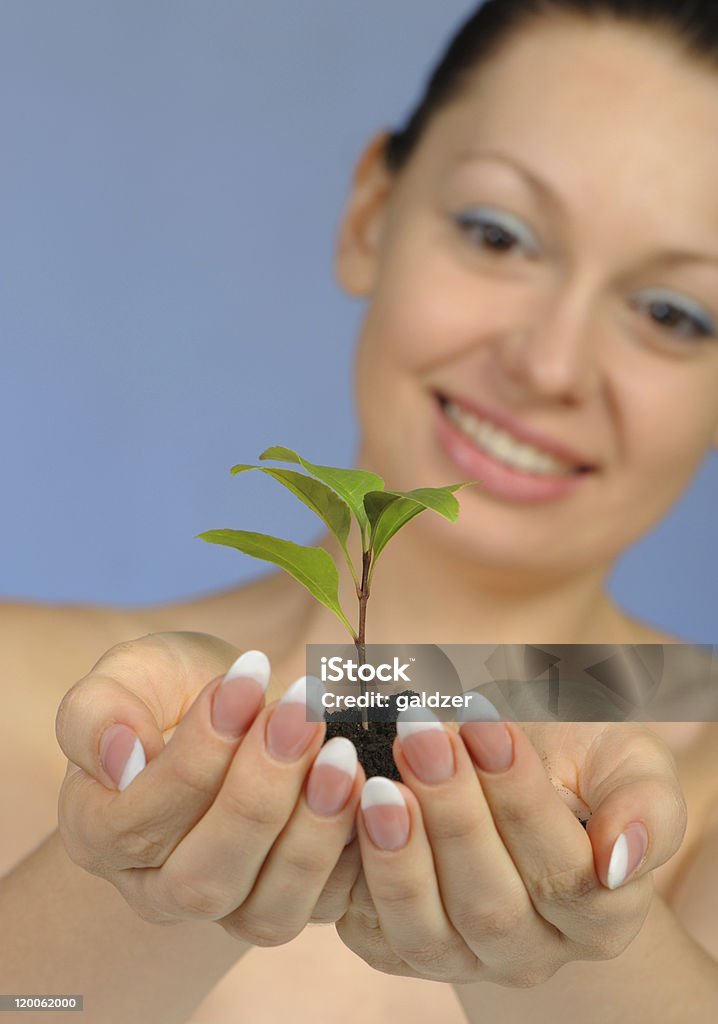 La femme a dans les mains du sol et une plante - Photo de Adulte libre de droits