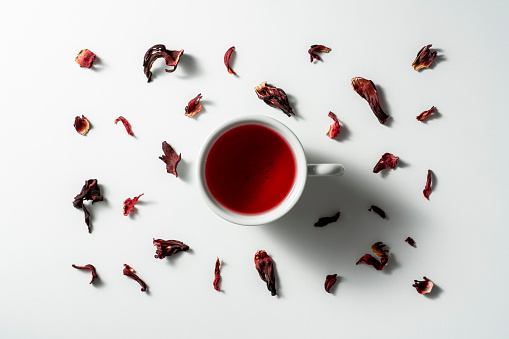 Hibiscus tea and dried hibiscus leaves on white background