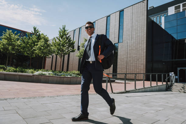 istock Jolly executive walking with rucksack stock photo 1200621748