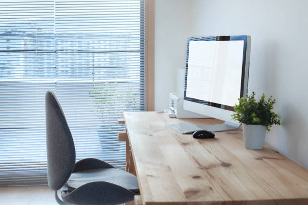 interior del espacio de trabajo con ordenador sobre mesa de madera y silla de oficina - simple living fotografías e imágenes de stock