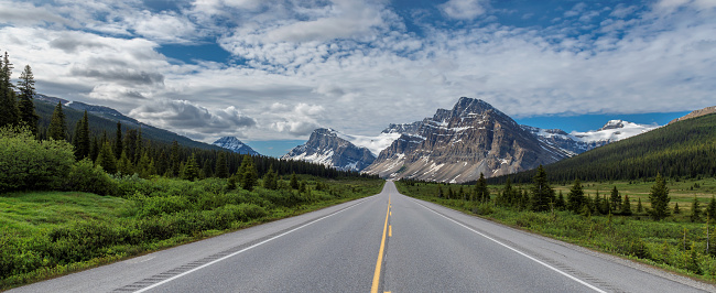 Icefields Parkway at Bow Lake - A summer morning panoramic view of Icefields Parkway extending towards Bow Lake, with Bow Crow Peak, Crowfoot Glacier and Crowfoot Mountain rising high behind, Banff National Park, AB, Canada