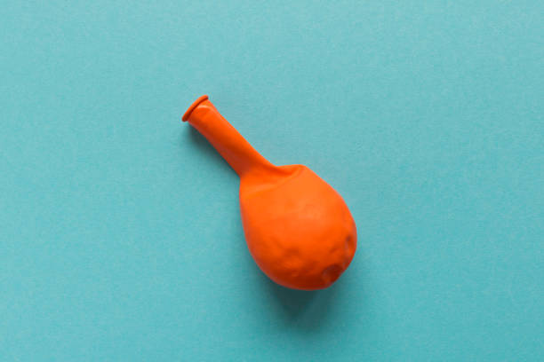 A deflated orange balloon on a blue background