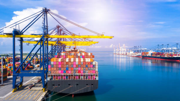 istock Container ship at industrial port loading and unloading containers in import export business logistic and transportation of international by container ship in the open sea. 1200657574