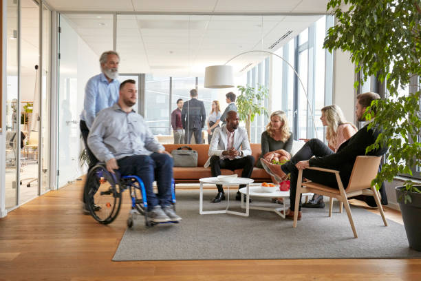 istock Mature Business Executive Wheeling Colleague Through Lobby 1200658852