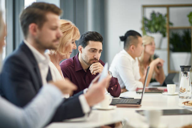 istock Side View of Executives at Board Room Table 1200658862
