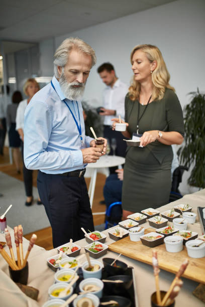 istock CEO and Female Executive Selecting Small Dishes at Buffet 1200658870