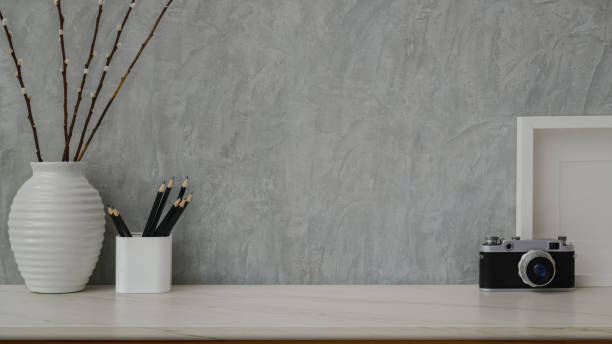 istock Cropped shot of workspace with copy space, mock up frame and decorations on marble desk with loft wall 1200660610