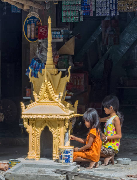 Yellow pagoda - Tra Vinh Tra Vinh, Vietnam - February 2, 2016: Children paint a yellow pagoda in preparation for the Vietnamese New Year vietnamese girls for sale stock pictures, royalty-free photos & images