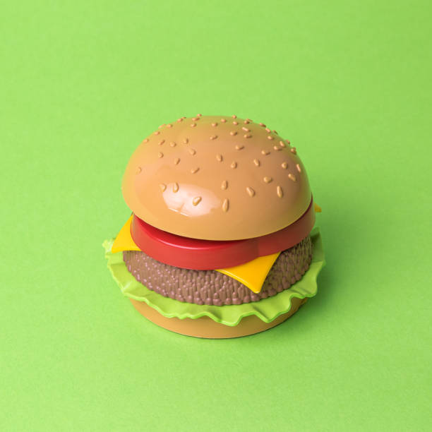 istock Artificial hamburger with cheese tomatoes and lettuce abstract on green. 1200663351